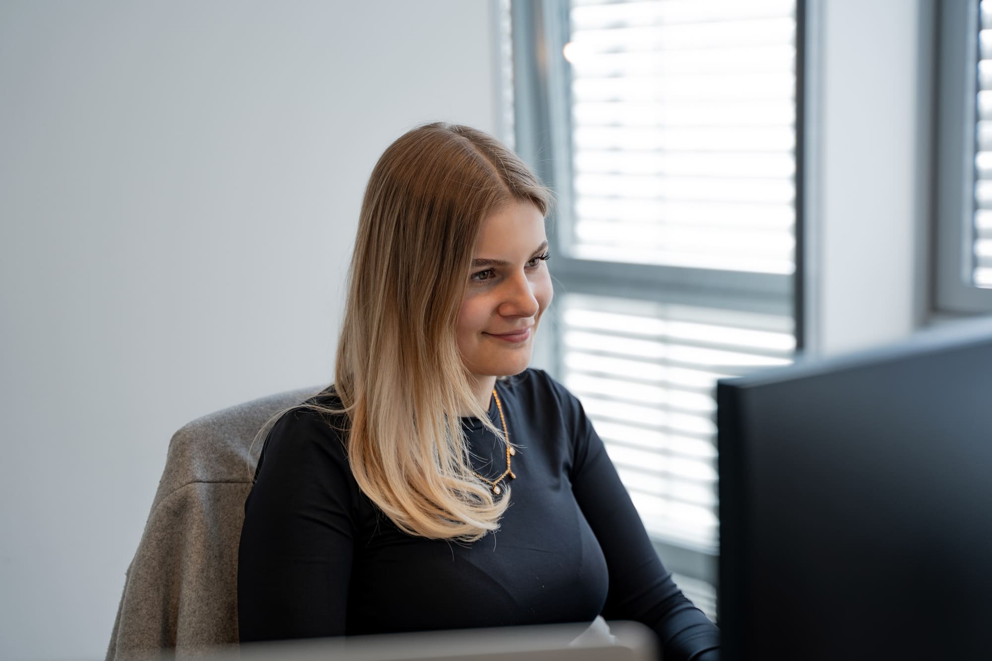Leonie von digitalbynature® am Arbeitsplatz am Fenster
