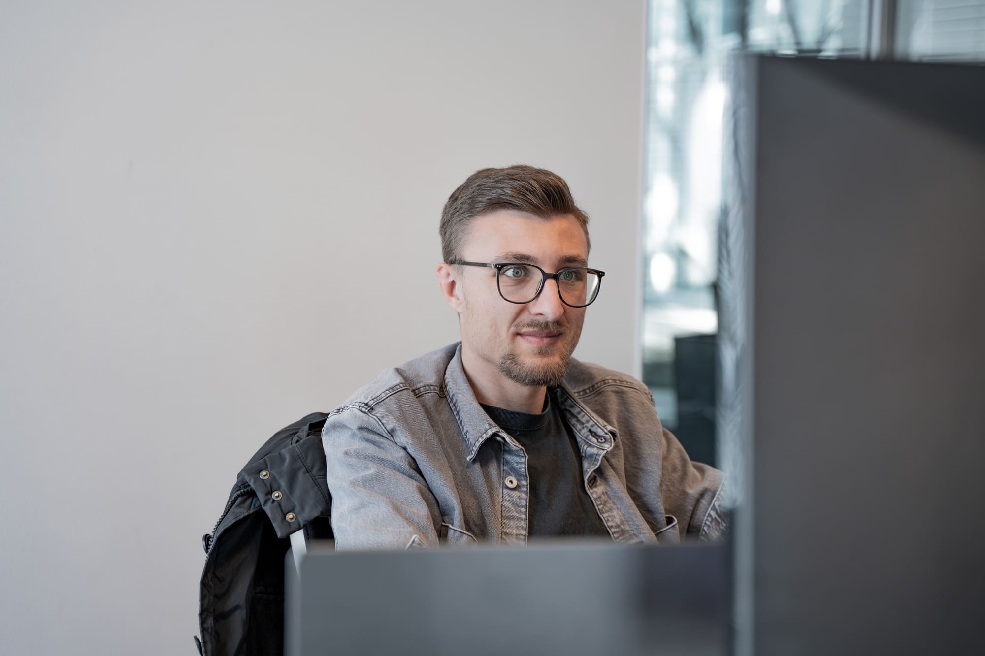 Pascal von digitalbynature® bei der Arbeit am Rechner im hellen Büro