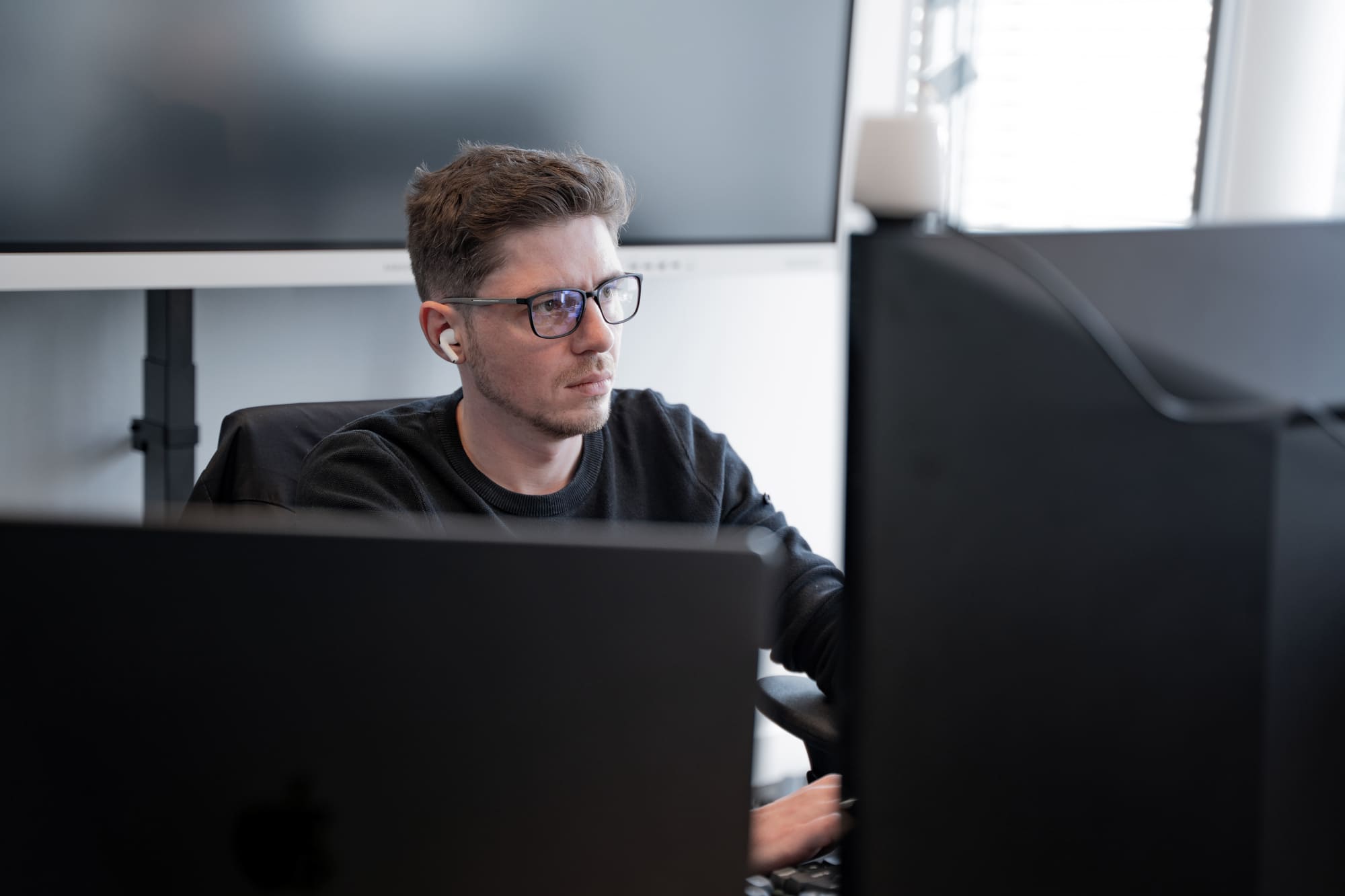 Sergej von digitalbynature® konzentriert vor dem Bildschirm im Büro