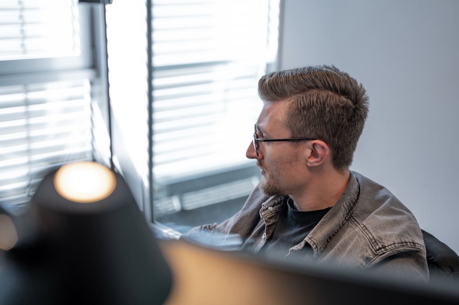 Mitarbeiter von digitalbynature® am Arbeitsplatz im Fensterlicht